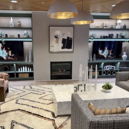 a clubroom with tv's, couches and a fireplace